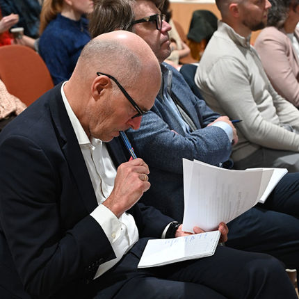 Jurymedlem tenker og konsulterer notater.