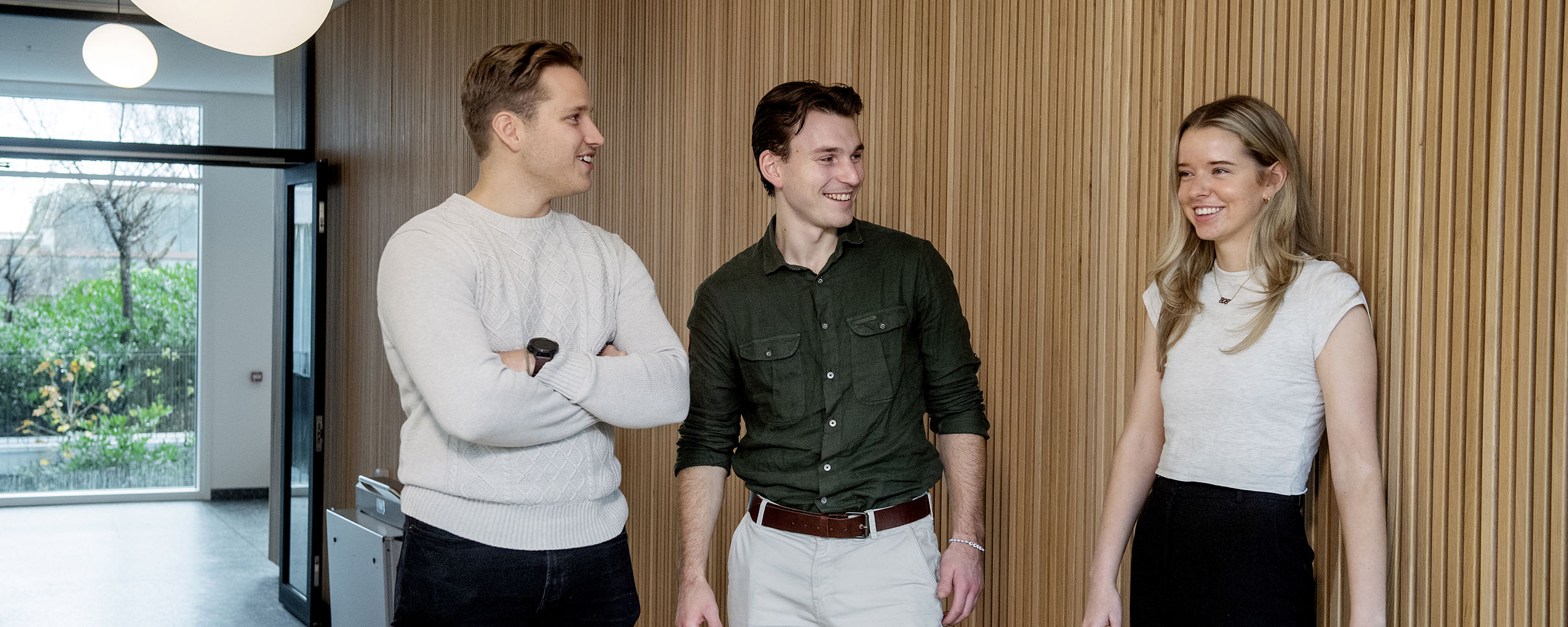 Tre studenter som står og snakker sammen. Foto: Helge Skodvin 