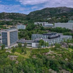 Aerial view of the Norwegian School of Economics (NHH) in Bergen, surrounded by greenery and residential houses.