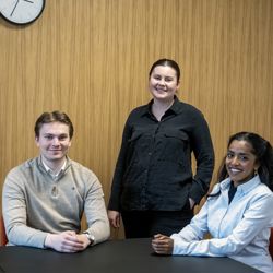 Leder i Økonomiforeningen Stine Sjøhaug (til høyre) merker at folk har presset privatøkonomi: – Vi får langt flere henvendelser enn tidligere. Økonomiforeningen hadde forventet økt pågang etter pandemien, men så kom de store strømregninger på toppen, sier hun. Her sammen med informasjonsansvarlig Håvard Fagerholt og Thiviya Sivapalan, samarbeidsansvarlig i den studentdrevne organisasjonen. Foto Helge Skodvin